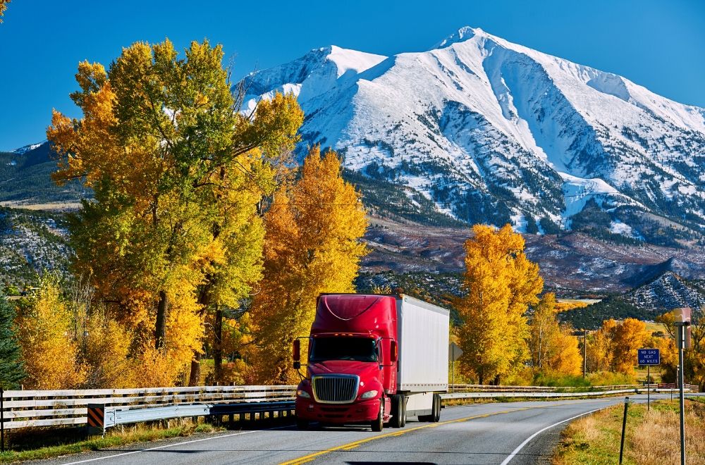 FreightSaver semi truck driving through mountains