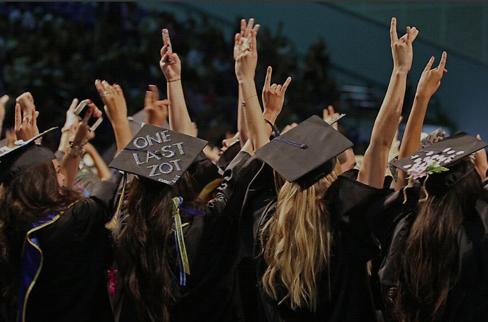 UCI graduates with hands in air